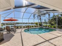 Inviting pool area with screened enclosure, overlooking a lake at 1374 Brenner Park Dr, Venice, FL 34292