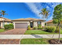 Single-story home with brown garage door, landscaping, and palm trees at 13836 Karina St, Venice, FL 34293