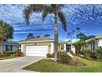 Single-story home with white garage door and palm tree in front at 1655 Lancashire Dr # 1655, Venice, FL 34293