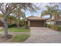 House exterior featuring a two-car garage and landscaped yard at 19155 Mangieri St, Venice, FL 34293