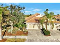 Single-story villa with tile roof, two-car garage, and landscaped yard at 4259 Whispering Oaks Dr, North Port, FL 34287