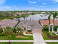 Aerial view of a beautiful home on a lake with lush landscaping at 430 Marsh Creek Rd, Venice, FL 34292