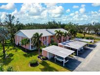 Aerial view of condo building with parking and lush landscaping at 458 Cerromar Rd # 483, Venice, FL 34293