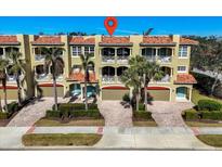 Three-story townhouses with balconies, garages, and palm trees at 702 Granada Ave # 7, Venice, FL 34285