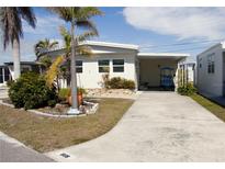 Single-story home with covered carport, landscaping, and paved driveway at 808 S Green Cir, Venice, FL 34285