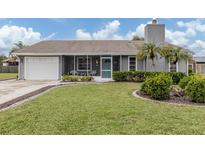 Gray house with white garage door, landscaped lawn, and screened porch at 842 Linden Rd, Venice, FL 34293