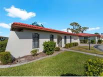 Spanish style home with red tile roof, landscaping, and walkway at 854 Senda Plata # 22, Venice, FL 34293
