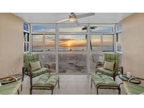 Relaxing sunroom boasts stunning sunset views and comfortable seating at 255 The Esplanade N # 202, Venice, FL 34285