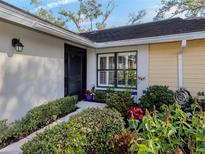 Inviting exterior with landscaped walkway, lush greenery, and a charming entrance at 341 Pembroke Ln # 227, Venice, FL 34293