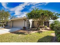 Attractive exterior of a single-story home with a well-maintained lawn and landscaping at 4619 Forest Wood Trl # 7, Sarasota, FL 34241