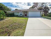 Single-story house with a white garage door and a long driveway at 4695 W Price Blvd, North Port, FL 34286