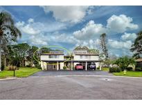 Two-story condo building with carport and lush landscaping at 647 White Pine Tree Rd # 34, Venice, FL 34285