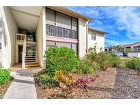 Exterior view of condo building with landscaped grounds and walkway at 756 White Pine Tree Rd # 211, Venice, FL 34285