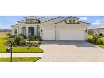Beautiful two-story home featuring a three-car garage and lush landscaping at 11140 Hogan Cir, Englewood, FL 34223