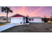 White house with red accents, single-car garage, and landscaped lawn at 237 Venice East Blvd, Venice, FL 34293