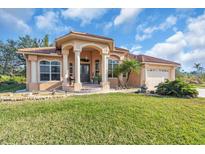 Attractive one-story home with a tile roof, columns, and landscaped lawn at 3162 Cordova Ter, North Port, FL 34291