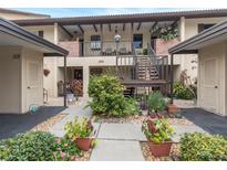 Exterior view of condo building with well-maintained landscaping and walkway at 340 Three Lakes Ln # K, Venice, FL 34285