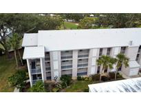 Condo building exterior, featuring light-colored roof and balconies at 437 Cerromar Ln # 513, Venice, FL 34293