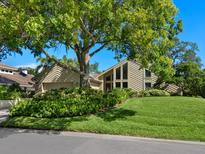 Charming home featuring a well-manicured lawn and mature landscaping with an architectural window feature at 128 Sea Anchor Dr, Osprey, FL 34229