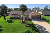 Charming one-story home featuring lush green lawn, mature palms, and a welcoming two-car garage at 1773 Hudson St, Englewood, FL 34223