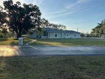 Single-story house with a large front yard and spacious driveway at 1800 Whispering Pines Cir, Englewood, FL 34223