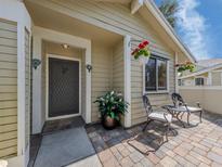 Charming front entrance featuring a cozy brick patio with seating and decorative flowerpots at 3020 Sail Pointe Cir # 5A, Venice, FL 34293