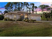 Charming home with a well-manicured lawn, mature trees, and a two-car garage at 3415 N Cranberry Blvd, North Port, FL 34286