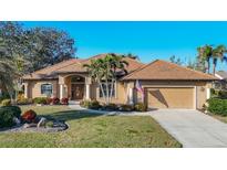 Charming single-story home featuring a well-maintained lawn, mature trees, and a two-car garage at 389 Eden Dr, Englewood, FL 34223