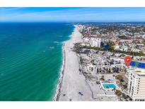 Stunning aerial view of beachside condos with pool and the Gulf's turquoise waters and sandy beach at 700 Golden Beach Blvd # 221, Venice, FL 34285