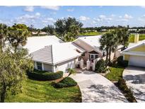 Beautiful exterior elevation showcases mature landscaping, neutral paint, and a white tile roof at 734 Brightside Crescent Dr # 18, Venice, FL 34293