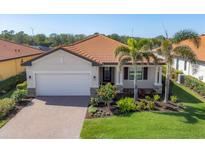 Charming single Gathering home with a well manicured lawn, paver driveway, and a tile roof at 10181 Colubrina Dr, Venice, FL 34293