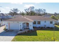 Charming single-story home with a manicured lawn, an attached garage, and nautical-themed decor at 1181 Southland Rd, Venice, FL 34293