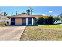 Charming single-story home with a well-maintained lawn and mature trees at 12321 Alta Mira St, North Port, FL 34287