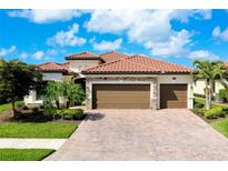 Beautiful single-Gathering home featuring a red tile roof, three-car garage, and a paved driveway at 13730 Vancanza, Venice, FL 34293