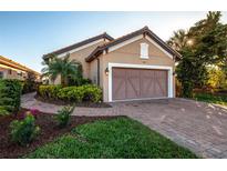 Charming home featuring a lush, manicured lawn and an attached two-car garage with a brick paved driveway at 5505 Cantucci St, Nokomis, FL 34275