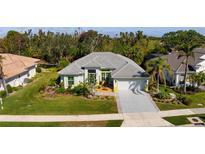 Charming single-story home with a gray tile roof, fresh landscaping, and an attached two-car garage at 707 Petrel Way, Venice, FL 34285