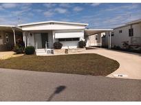 Charming single-story home featuring a covered carport and well-maintained lawn at 718 S Green Cir, Venice, FL 34285