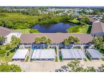 An aerial view of this condo features assigned covered parking and a peaceful pond surrounded by lush landscaping at 811 Waterside Dr # 102, Venice, FL 34285