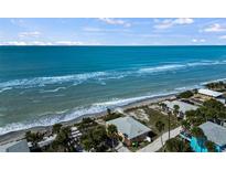 Aerial view of a beachfront property with clear turquoise water, sandy beach, and blue skies at 4074 N Beach Rd # Ctg5, Englewood, FL 34223