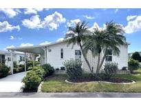 Charming single-story home with carport, lush landscaping, and decorative palm trees at 473 Sharks Pt, North Port, FL 34287