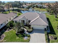 Stunning home with lush landscaping and a pond view, complete with fountain at 5071 Winter Rose Way, Venice, FL 34293