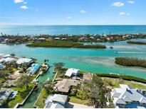 Gorgeous aerial view of coastal homes on the water with stunning turquoise inlets and blue ocean views at 641 Bayshore Rd, Nokomis, FL 34275