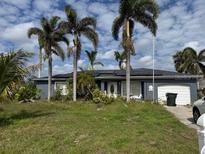 Charming single-story home with a well-maintained lawn and mature palm trees at 6678 Acmar Ct, North Port, FL 34287