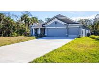 Inviting single-story home featuring a 3-car garage and a long driveway at 5637 Ocarina Rd, North Port, FL 34291