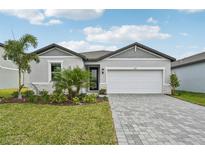 Single-story home with gray siding, landscaping, and a paved driveway at 494 Sun Chaser Dr, Nokomis, FL 34275