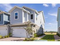 Two-story townhome with gray siding, white garage door, and landscaped walkway at 17355 Peregrine Way, Punta Gorda, FL 33982