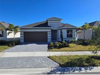 Two-story house with brown garage door, and palm trees at 9576 Vibrant Lane, Venice, FL 34292