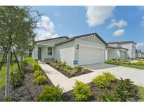 One-story home with a landscaped front yard, attached garage, and walkway at 396 Lazy Shore Dr, Nokomis, FL 34275