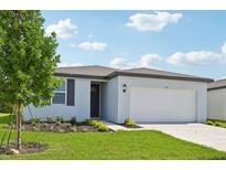 One-story home with white exterior, gray roof, and a two-car garage at 156 Lazy Shore Dr, Nokomis, FL 34275