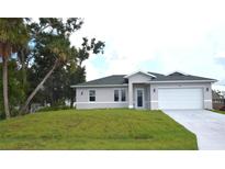 Newly constructed one-story home with a two-car garage and lush lawn at 23335 Mac Dougall Ave, Port Charlotte, FL 33980